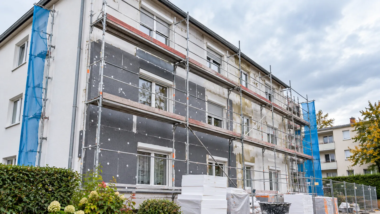 Mehrfamilienhaus mit Gerüst während der Fassadendämmung